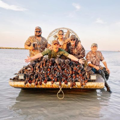 group of guys showing off ducks from duck hunt on airboat